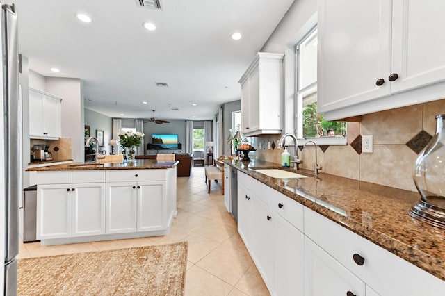 2256 Ridgewood Ct, Royal Palm Beach, FL 33411 - kitchen with open floor plan, recessed lighting, backsplash, dark stone counters, and white cabinets