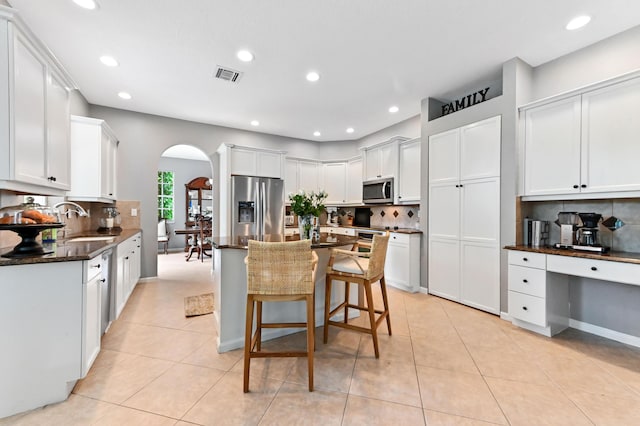 2256 Ridgewood Ct, Royal Palm Beach, FL 33411 - kitchen with stainless steel appliances, arched walkways, tasteful backsplash, recessed lighting, and a breakfast bar