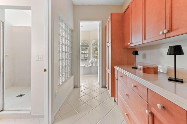 2256 Ridgewood Ct, Royal Palm Beach, FL 33411 - kitchen featuring light countertops, light tile patterned flooring, and brown cabinetry