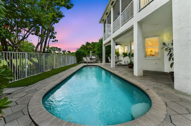 2256 Ridgewood Ct, Royal Palm Beach, FL 33411 - pool at dusk featuring a patio, a fenced backyard, and ceiling fan