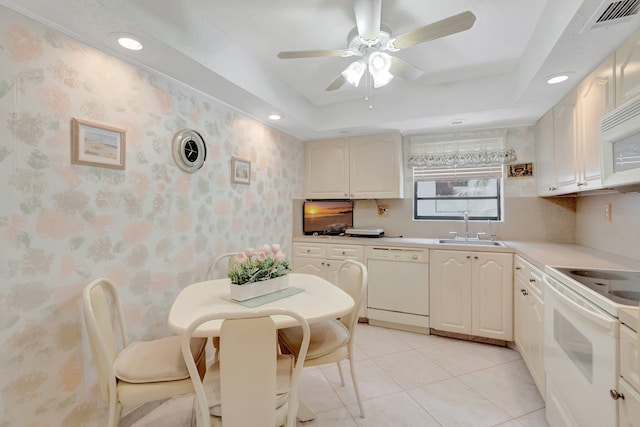 544 Piedmont L, Delray Beach, FL 33484 - kitchen with visible vents, white appliances, ceiling fan, a raised ceiling, and a sink