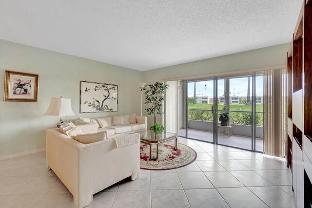 544 Piedmont L, Delray Beach, FL 33484 - living room featuring baseboards, a textured ceiling, and light tile patterned floors
