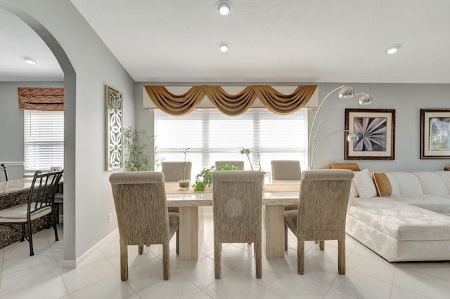 dining room with arched walkways, baseboards, and recessed lighting