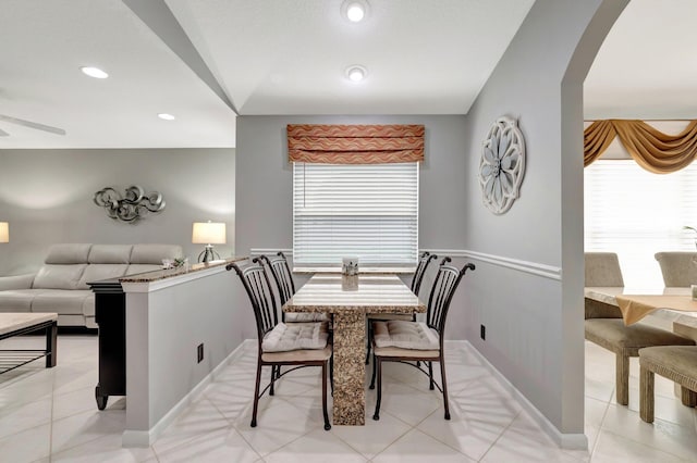 dining space with arched walkways, baseboards, recessed lighting, and light tile patterned flooring