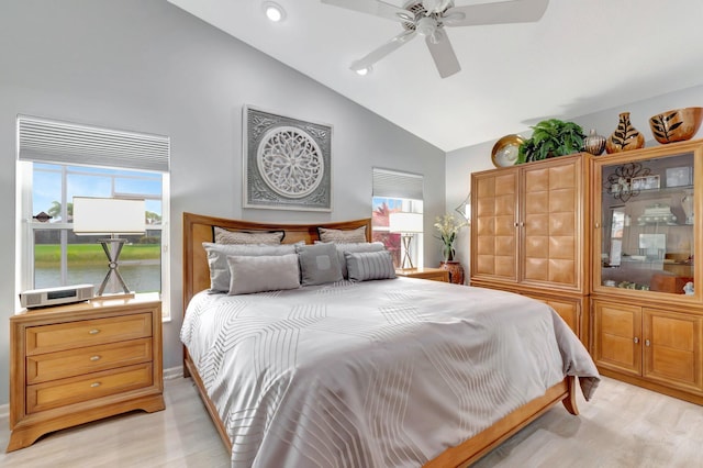 bedroom featuring light wood-style flooring, ceiling fan, multiple windows, and high vaulted ceiling