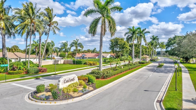 view of street featuring a residential view, sidewalks, curbs, and street lights