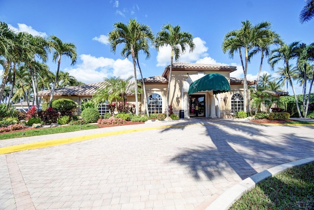 mediterranean / spanish-style house with french doors, stucco siding, and a tiled roof