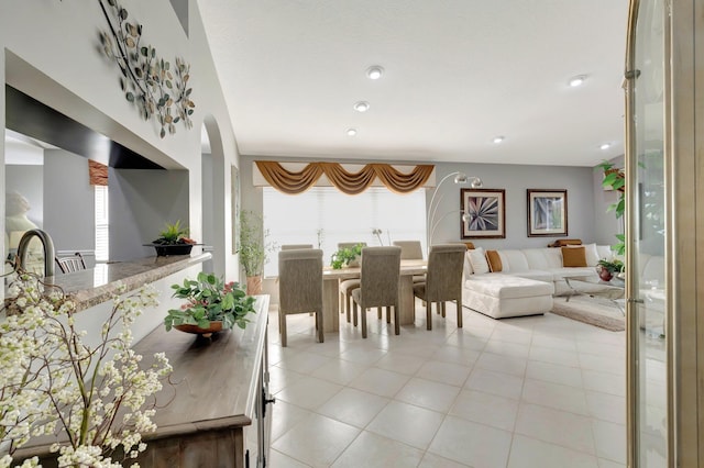 living area with light tile patterned floors, arched walkways, and recessed lighting