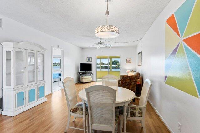 1118 Lake Ter Unit H209, Boynton Beach, FL 33426 - dining space with baseboards, a textured ceiling, ceiling fan, and wood finished floors