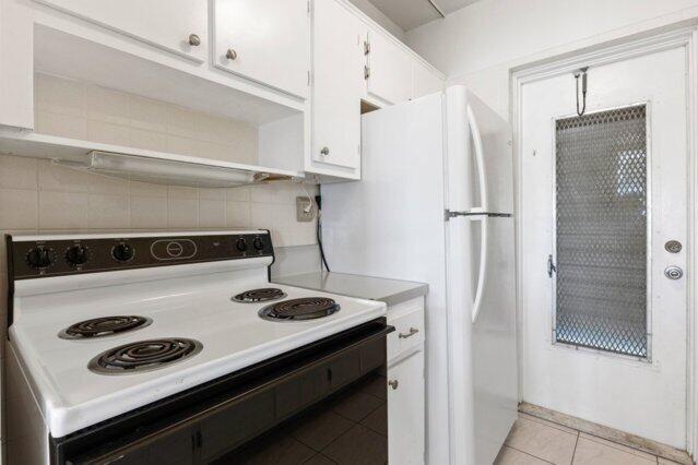 1118 Lake Ter Unit H209, Boynton Beach, FL 33426 - kitchen with electric range oven, open shelves, tasteful backsplash, a sink, and white cabinets