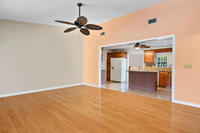 12610 63rd Ln N, The Acreage, FL 33412 - unfurnished living room with visible vents, a ceiling fan, and light wood-style flooring