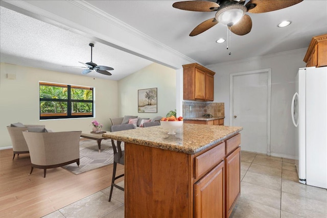 12610 63rd Ln N, The Acreage, FL 33412 - kitchen with freestanding refrigerator, a ceiling fan, open floor plan, and brown cabinets