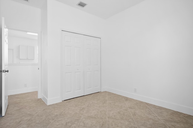 565 SW Feldman Ave N, Port Saint Lucie, FL 34953 - unfurnished bedroom with baseboards, a closet, light tile patterned flooring, and visible vents