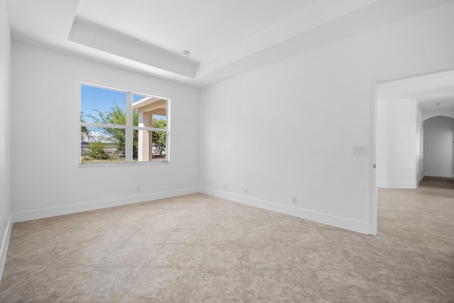 565 SW Feldman Ave N, Port Saint Lucie, FL 34953 - empty room featuring baseboards, arched walkways, and a tray ceiling