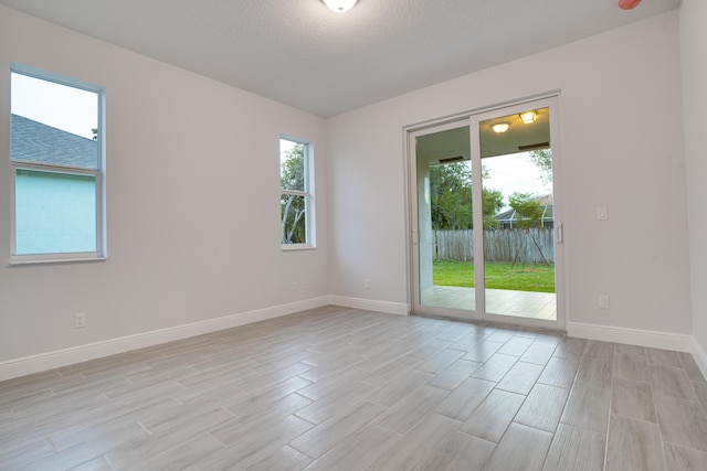 1634 SW Import Dr, Port Saint Lucie, FL 34953 - spare room featuring light wood-style floors, baseboards, and plenty of natural light