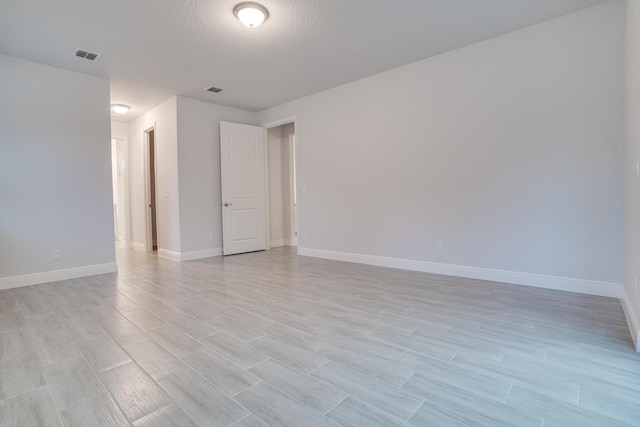 1634 SW Import Dr, Port Saint Lucie, FL 34953 - unfurnished room with visible vents, a textured ceiling, baseboards, and light wood finished floors
