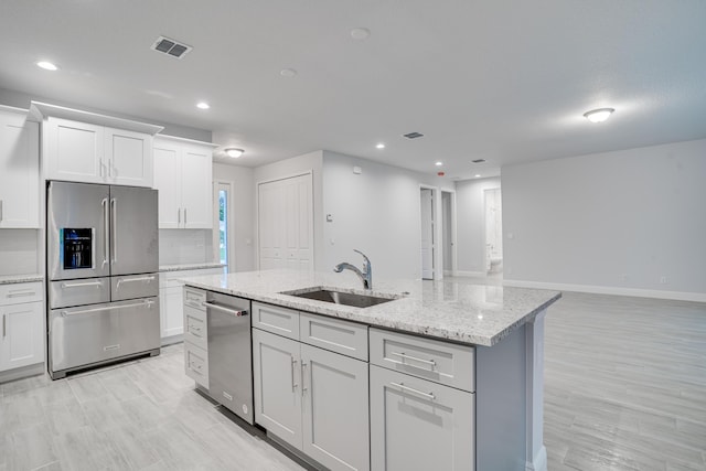 1634 SW Import Dr, Port Saint Lucie, FL 34953 - kitchen with white cabinets, appliances with stainless steel finishes, a sink, an island with sink, and visible vents