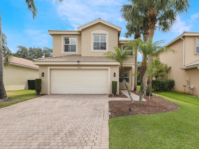 view of front of house with a tile roof, a garage, stucco siding, a front yard, and decorative driveway