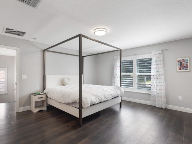 bedroom with multiple windows, wood finished floors, and visible vents