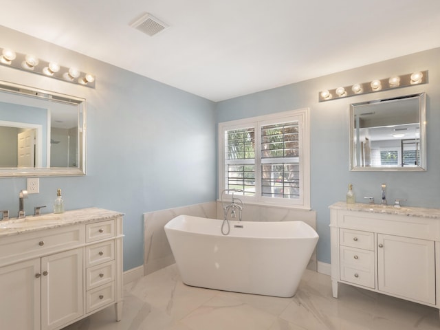 bathroom featuring a soaking tub, visible vents, a sink, and marble finish floor