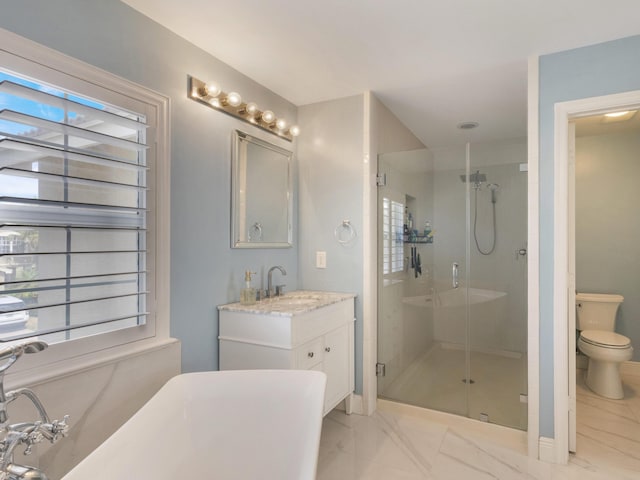 full bathroom with vanity, toilet, marble finish floor, a freestanding tub, and a shower stall