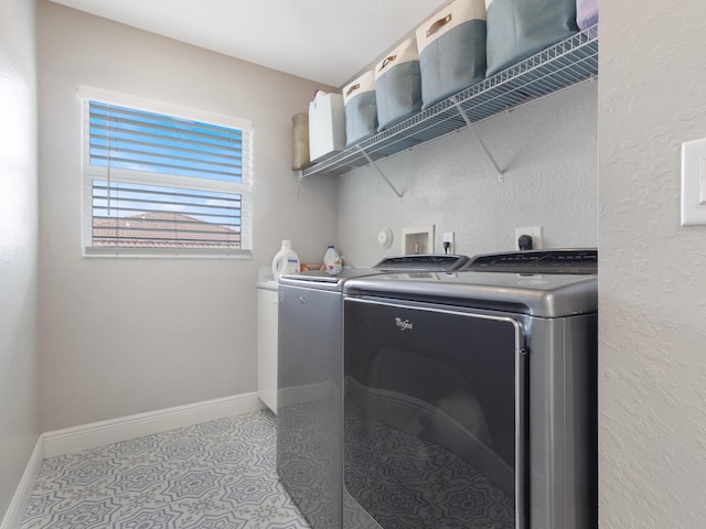 clothes washing area with washer and dryer, laundry area, and baseboards