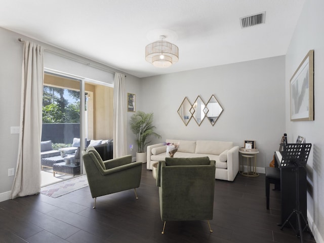 living area featuring baseboards, dark wood finished floors, and visible vents