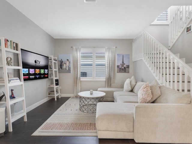 living area with baseboards, stairs, and wood finished floors