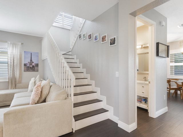 stairway with baseboards, wood finished floors, and visible vents