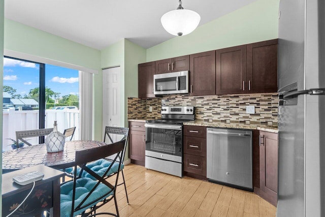 2641 Gately Dr W Unit 103, West Palm Beach, FL 33415 - kitchen with decorative backsplash, pendant lighting, appliances with stainless steel finishes, dark brown cabinets, and light wood-style flooring