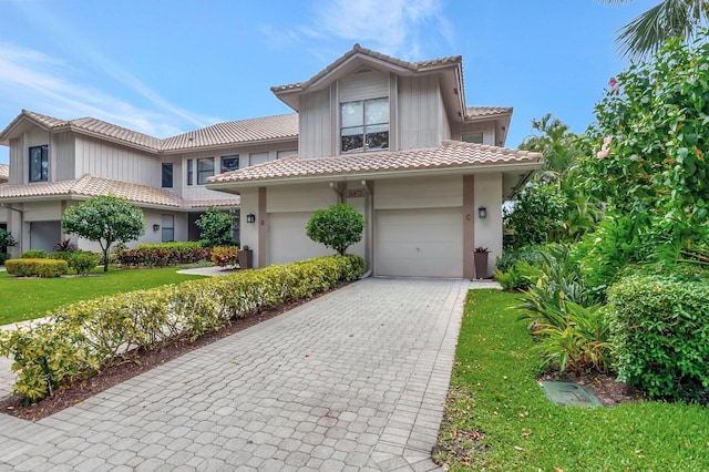 16873 Isle Of Palms Dr Unit C, Delray Beach, FL 33484 - mediterranean / spanish-style home featuring a front lawn, a tile roof, a garage, stucco siding, and decorative driveway