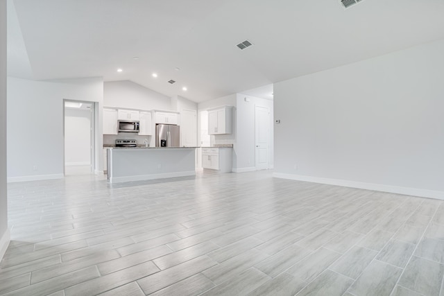206 SW Voltair Ter, Port Saint Lucie, FL 34984 - unfurnished living room featuring recessed lighting, vaulted ceiling, visible vents, and light wood-style floors