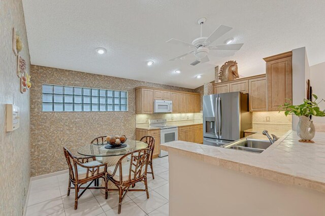 9870 Harbour Lake Cir, Boynton Beach, FL 33437 - kitchen with a sink, a ceiling fan, white appliances, and tasteful backsplash