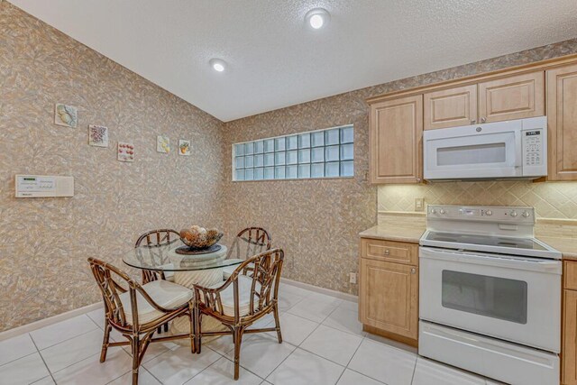 9870 Harbour Lake Cir, Boynton Beach, FL 33437 - kitchen with white appliances, a textured ceiling, light tile patterned floors, and light countertops