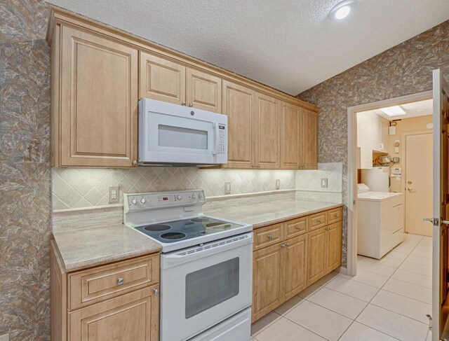 9870 Harbour Lake Cir, Boynton Beach, FL 33437 - kitchen with white appliances, light countertops, wallpapered walls, light tile patterned floors, and washing machine and dryer