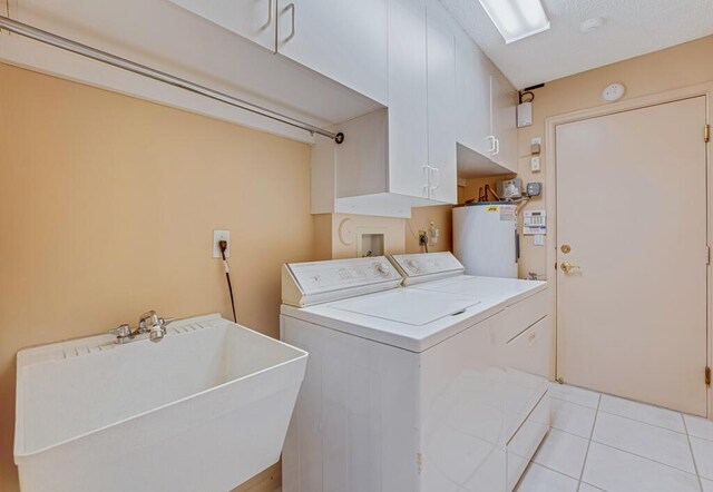 9870 Harbour Lake Cir, Boynton Beach, FL 33437 - washroom featuring cabinet space, washing machine and clothes dryer, a sink, water heater, and light tile patterned floors