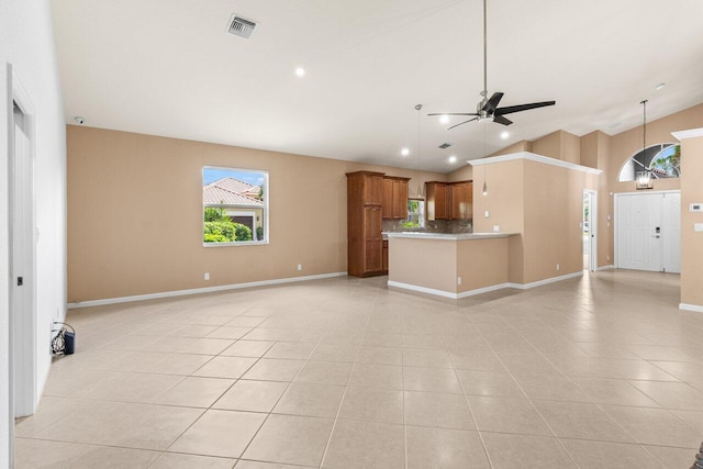 unfurnished living room featuring visible vents, ceiling fan, light tile patterned floors, and vaulted ceiling
