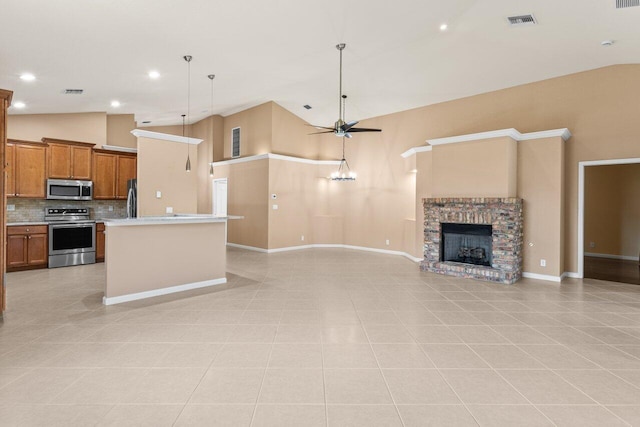 kitchen featuring appliances with stainless steel finishes, a ceiling fan, high vaulted ceiling, and open floor plan