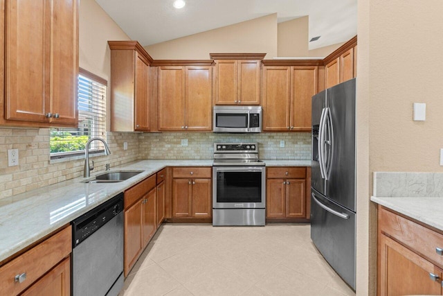 kitchen with backsplash, stainless steel appliances, a sink, and lofted ceiling