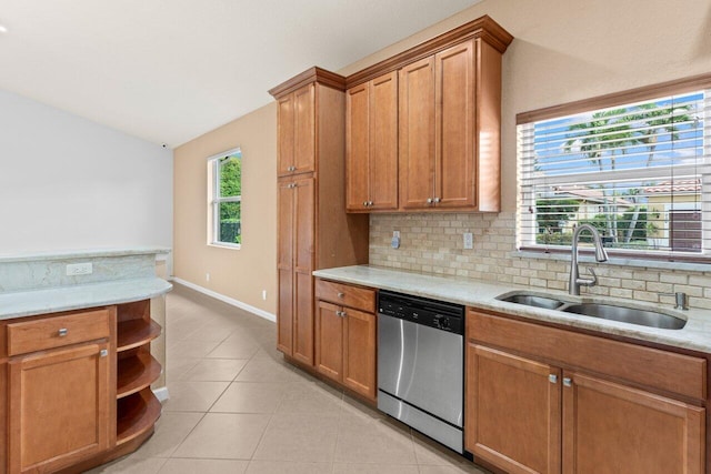kitchen with brown cabinetry, backsplash, dishwasher, a sink, and lofted ceiling
