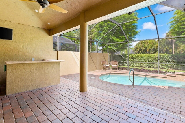 outdoor pool featuring ceiling fan, a patio area, and glass enclosure