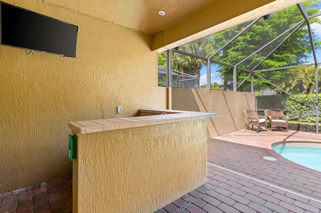 exterior space with a lanai, an outdoor pool, and outdoor dry bar