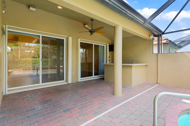 view of patio featuring glass enclosure and ceiling fan