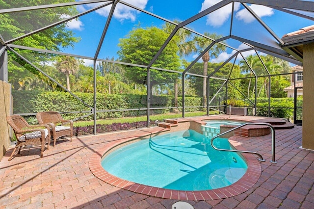 view of pool with a patio, a pool with connected hot tub, and glass enclosure
