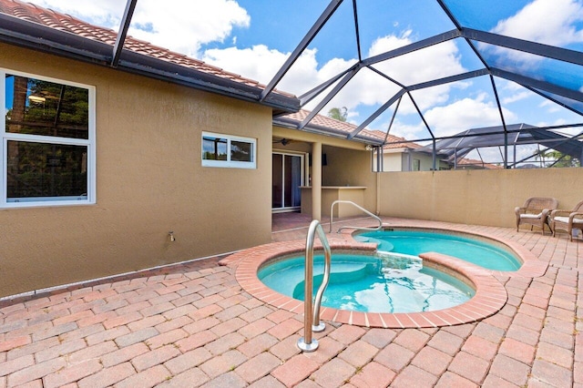 view of swimming pool featuring a patio area, a lanai, and an in ground hot tub
