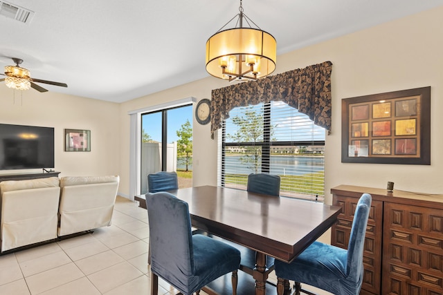 dining area with visible vents, light tile patterned floors, and ceiling fan with notable chandelier