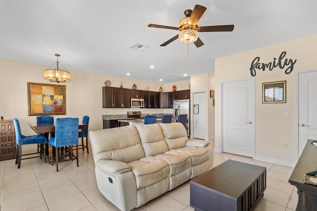 living room with ceiling fan, visible vents, light tile patterned floors, baseboards, and recessed lighting