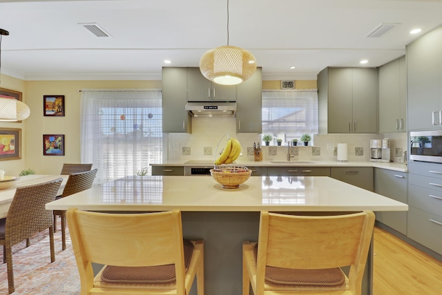 kitchen featuring gray cabinetry, a sink, and a healthy amount of sunlight