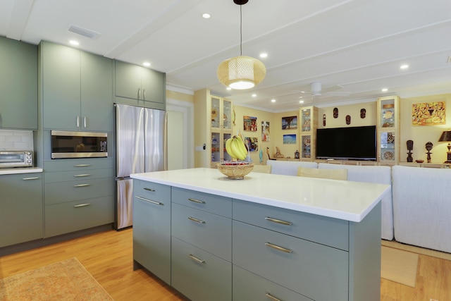 671 SW S River Dr Unit 207, Stuart, FL 34997 - kitchen featuring appliances with stainless steel finishes, light wood-style floors, light countertops, ornamental molding, and recessed lighting