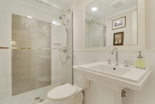 bathroom featuring a sink, a stall shower, toilet, and visible vents